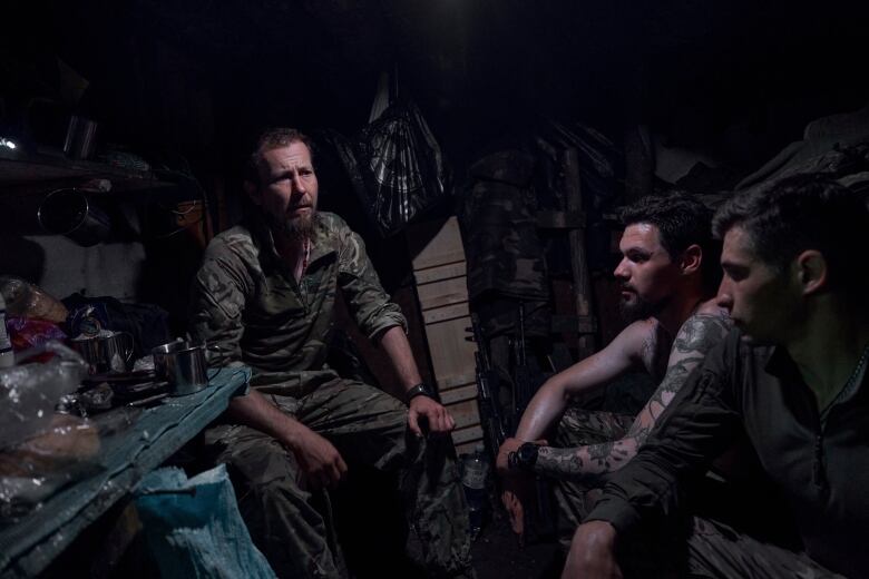 Ukrainian soldiers sit in a recently captured Russian trench on the frontline near Bakhmut, Donetsk region, Ukraine, Tuesday, July 4 2023. Ukrainian forces are making steady progress along the northern and southern flanks of Bakhmut, in a semi-encirclement of the wrecked city that Russian forces have been occupying since May. 