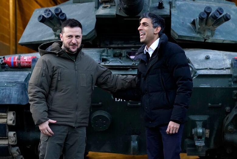 British Prime Minister Rishi Sunak, right, and Ukrainian President Volodymyr Zelensky meet Ukrainian troops being trained to command Challenger 2 tanks at a military facility in Lulworth, Dorset, England, Wednesday Feb. 8, 2023. 