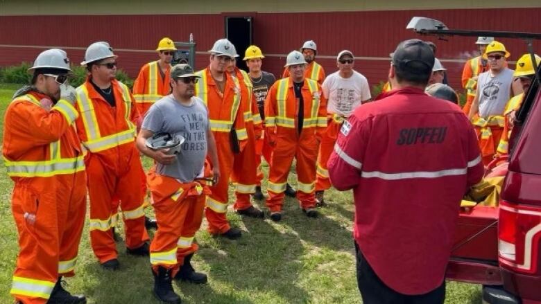 An instructor speaks with a group of Cree auxiliary trainees in fighting forest fires