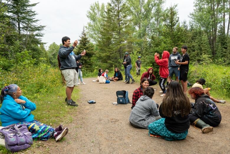 Dillon Koopmans teaches the youth at Aki Kikinomakaywin how to perform a stream assessment of the river connecting to Lake Tamblyn at Lakehead University.