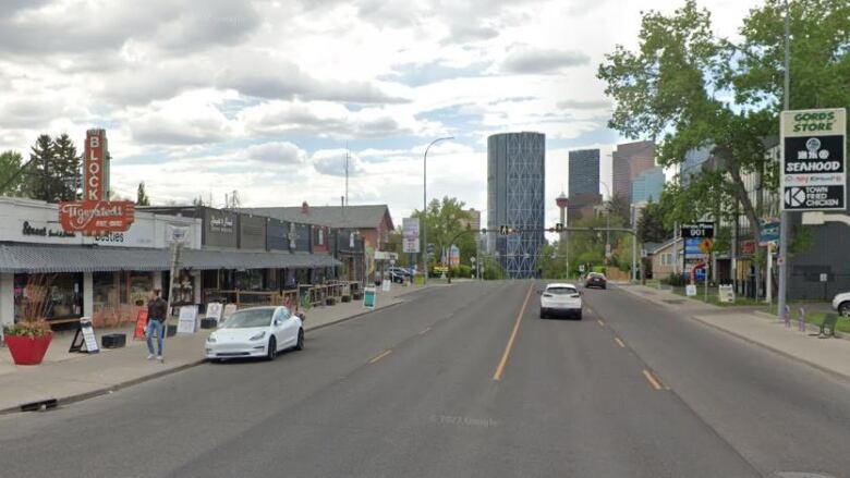 A wide street lined with shops at the side. 