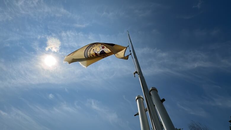 A flag reading Carry The Kettle flying in front of a blue sky