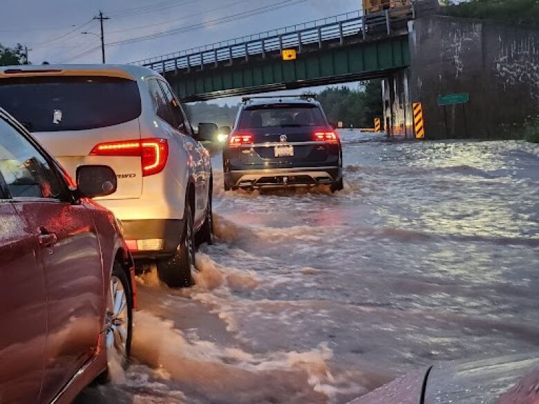 Cars are backed up on a flooded highway.