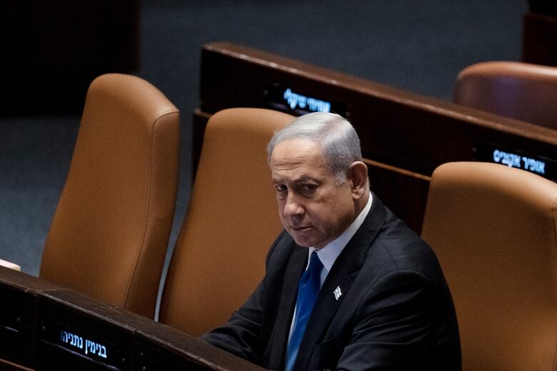 A person is seen sitting inside Israel's parliament. 