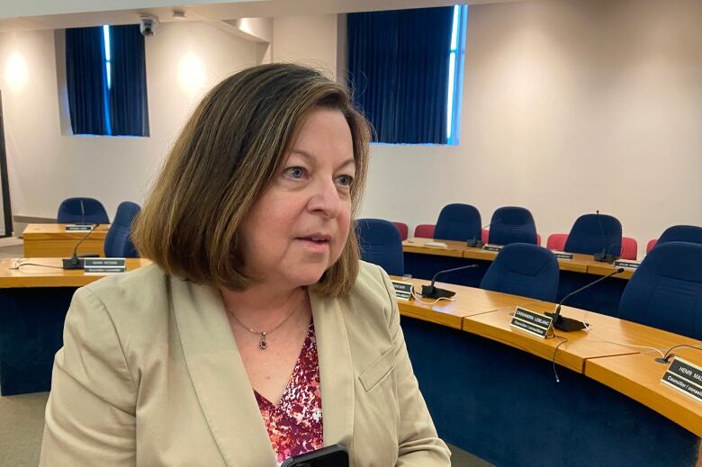 A woman wears a blazer inside Fredericton council chambers.