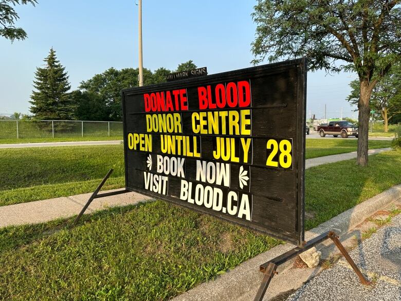 A sign along Grand Marais Avenue East in Windsor shows the city's blood donor clinic is closing July 28, 2023.