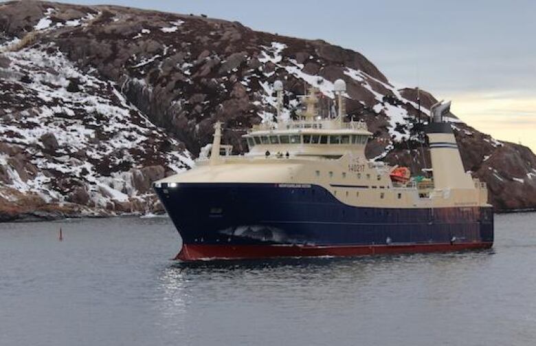 The Newfoundland Victor, a fishing trawler, glides into St. John's harbour during a winter scene.