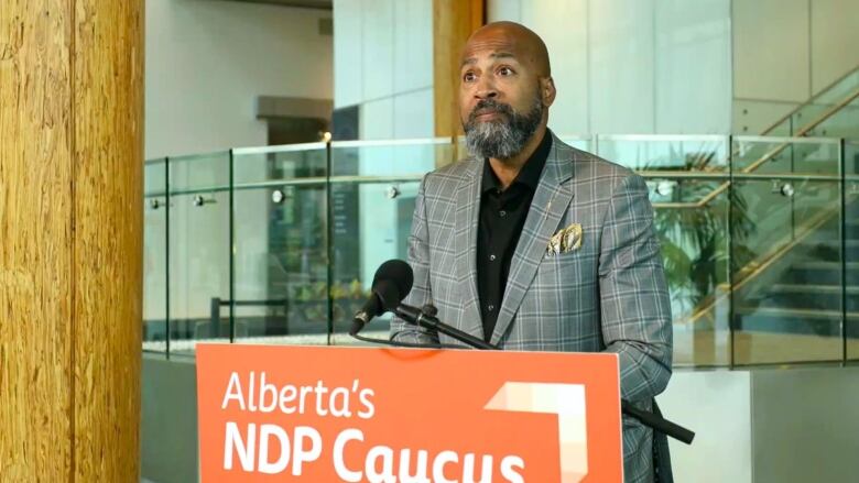 A man stands in front of a podium.