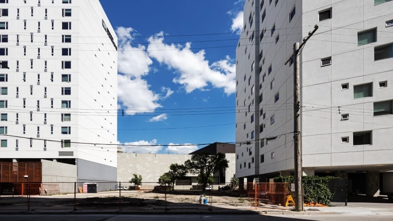 Vacant lot between two high-rise buildings.