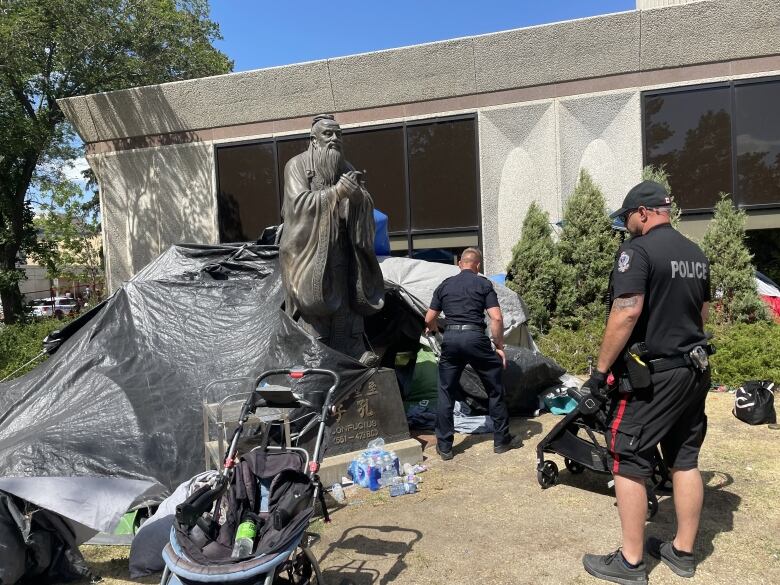 Two police officers can be seen beside some tents.