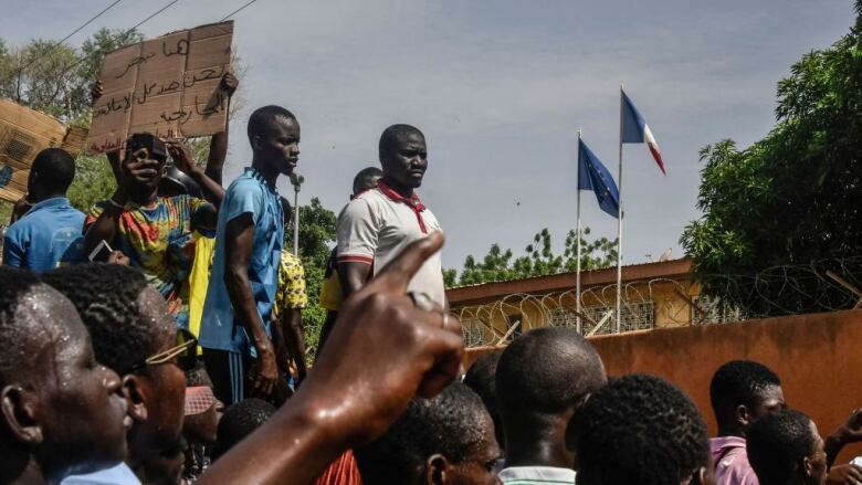 Protesters gather outside, in front of an embassy.