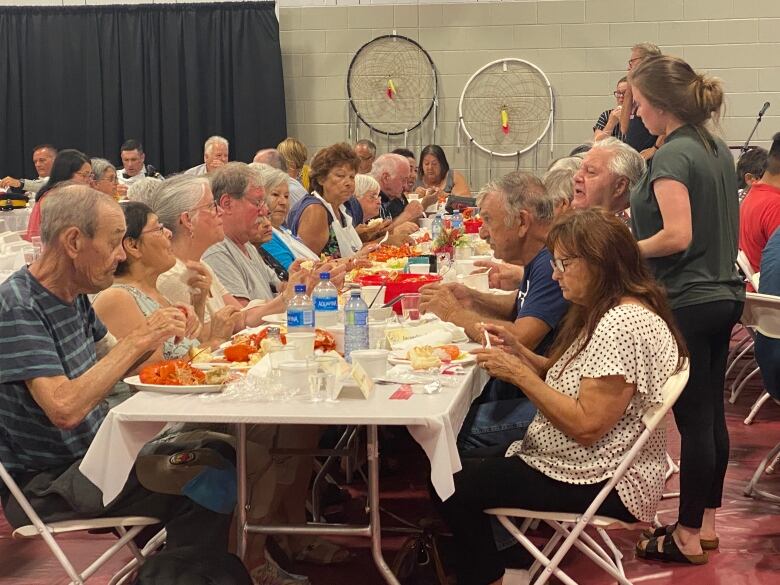 People sitting at a table eating lobster.