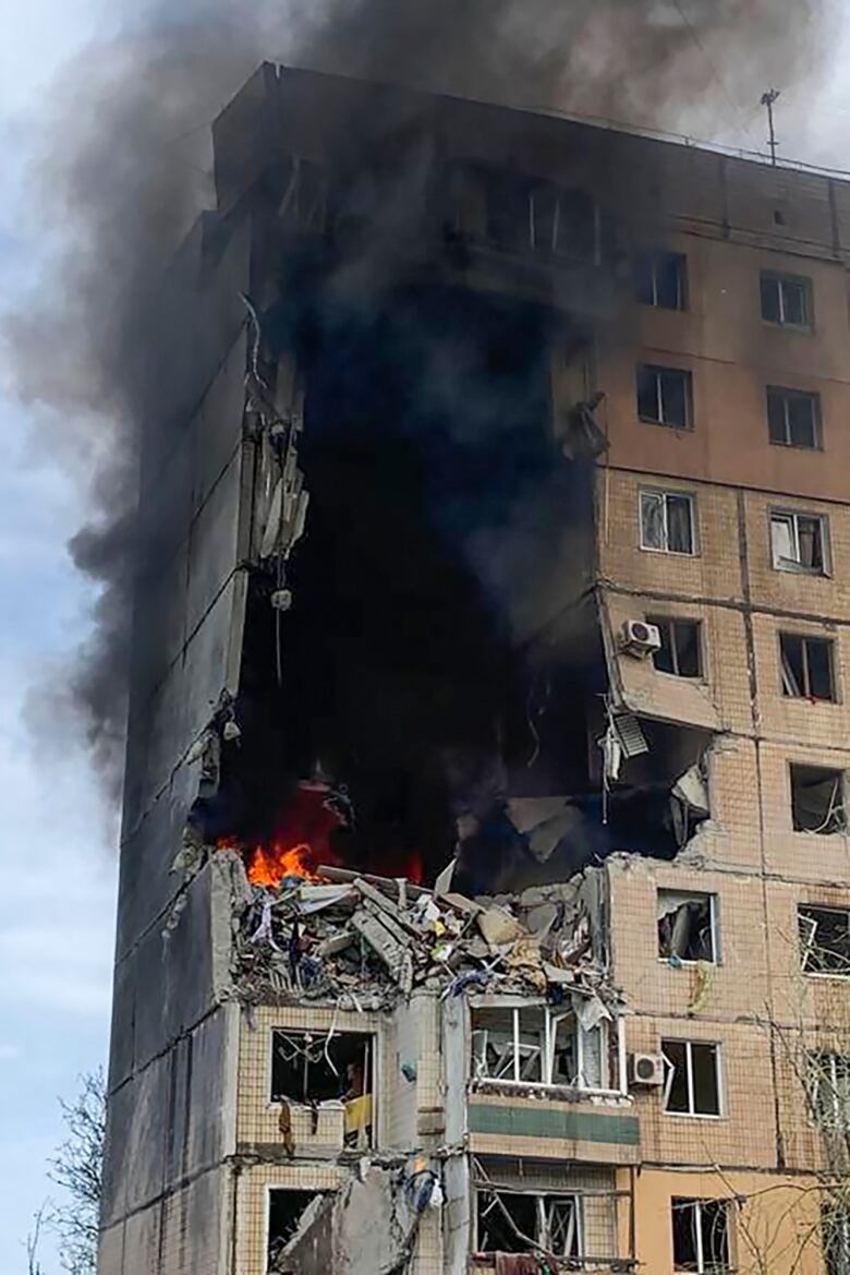 A gaping hole in a badly damage apartment building after a missile strike.