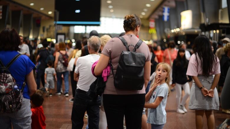 People line up in a train station.