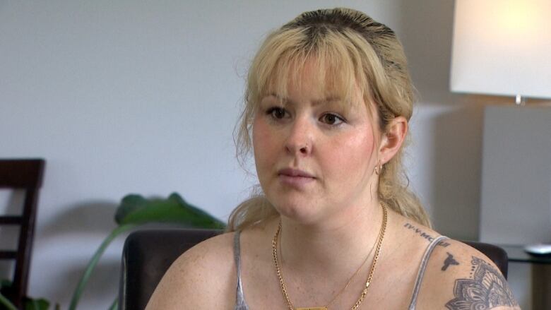 a woman with blonde hair and bangs looks concerned. 