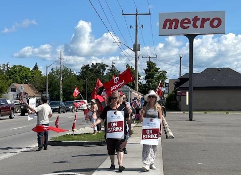 People with signs outside a Metro grocery store