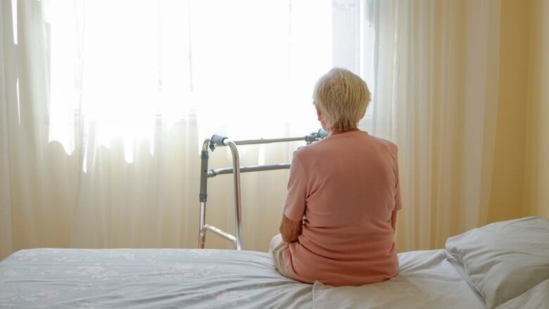 Elderly woman in nursing home room.