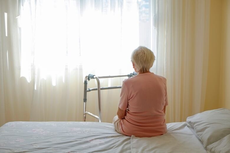 Elderly woman in nursing home room.