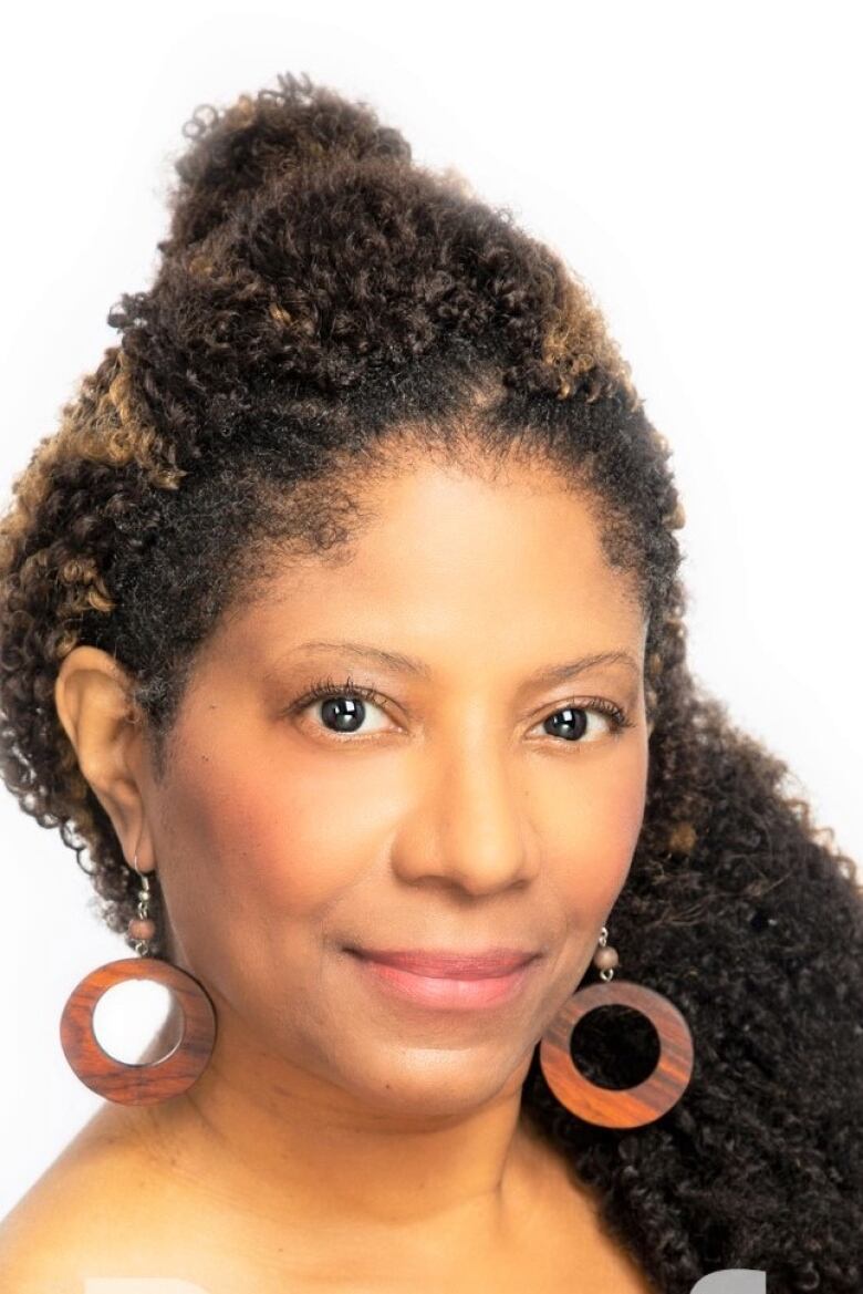 A headshot of a woman on a white backdrop