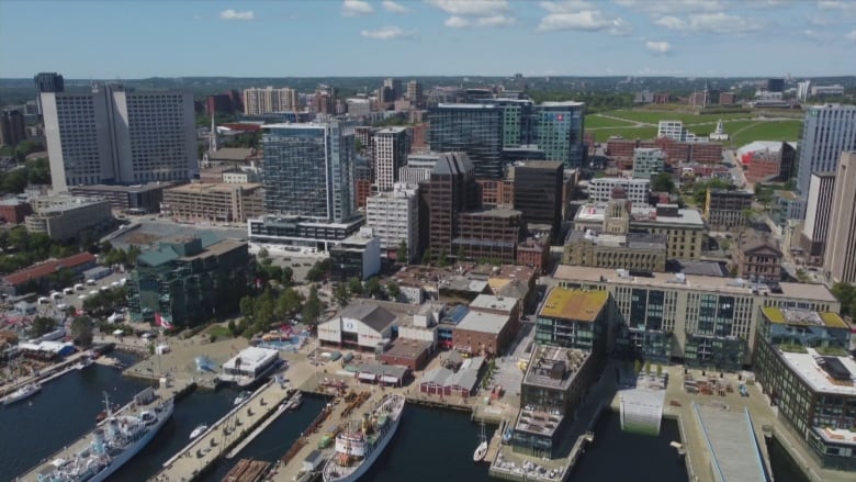 An aerial photo shows many buildings and part of a waterfront in a city's downtown area.