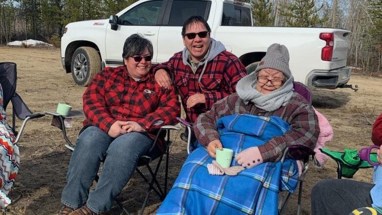 Three people bundled in warm clothes smiling