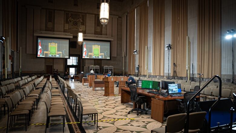 Screens line the rear wall of a temporary House of Commons chamber in Ottawa. The screens would allow for MPs to join proceedings virtually.