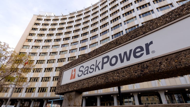 A sign that says SaskPower with a building behind it.