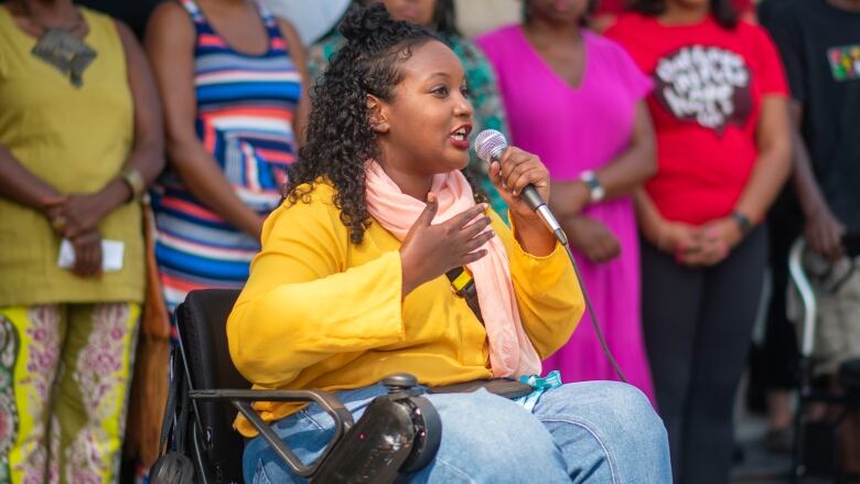 A woman speaking into a mic.