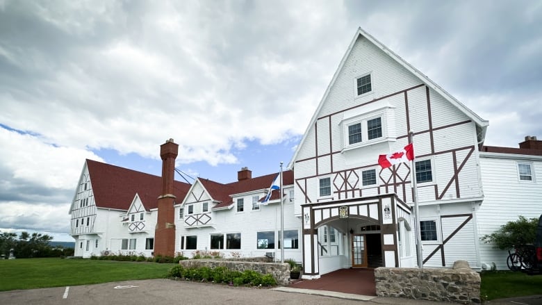 The white facade of an older resort building is shown.