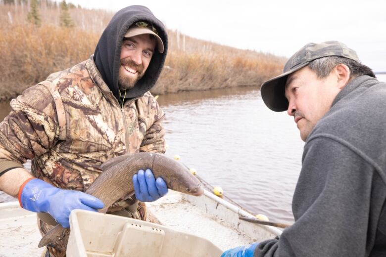 Jeremey Brammer, left, holding a white fish on the Porcupine River with Peter Frost, right, in 2021. 