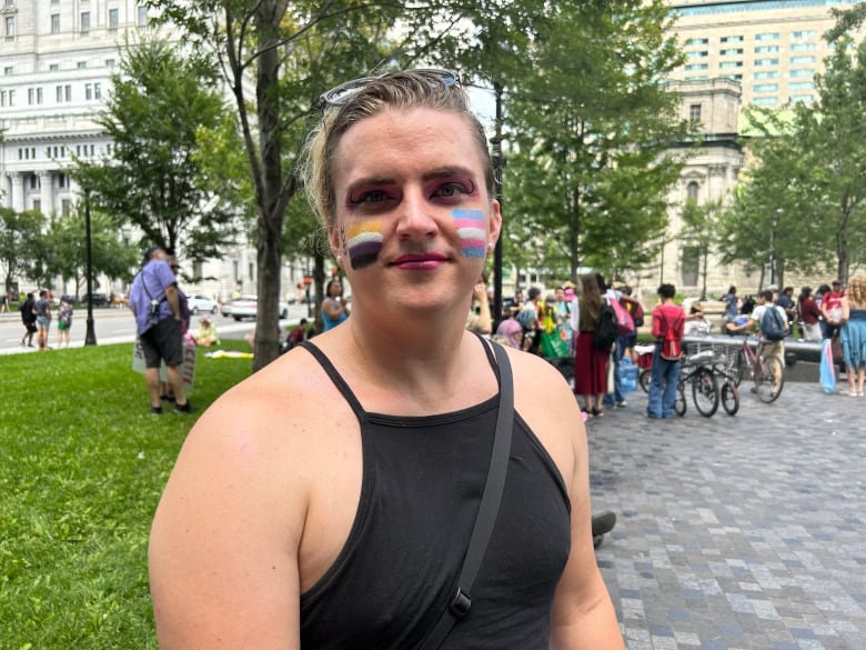 A person with a trans flag pride painted on their face. 