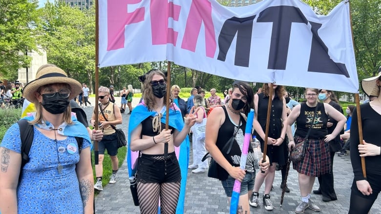 People hold up a sign reading 