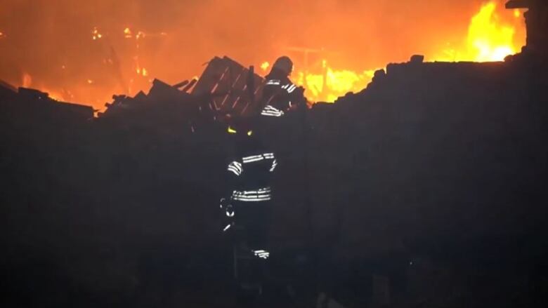 Firefighters work at the scene of destroyed grain elevator.