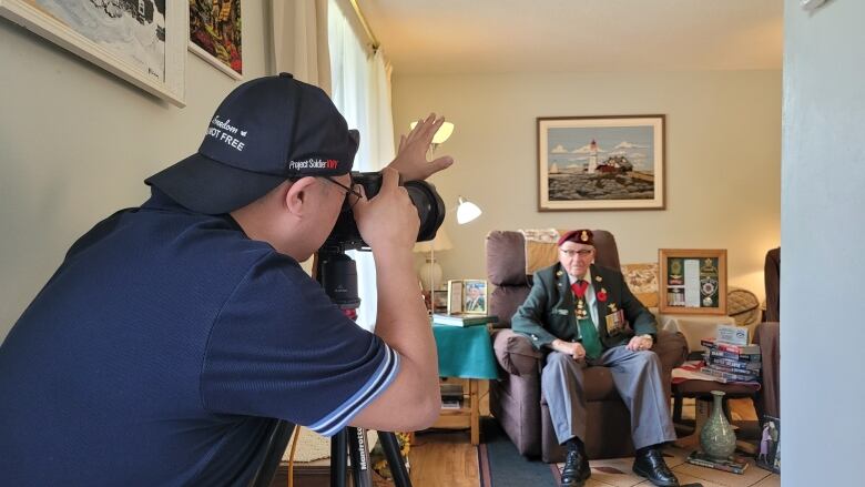 A man taking a photo of a veteran. 