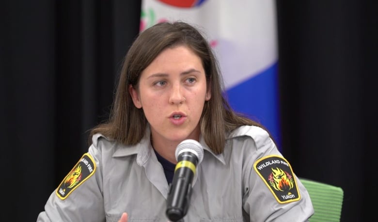 A woman speaks into a microphone.