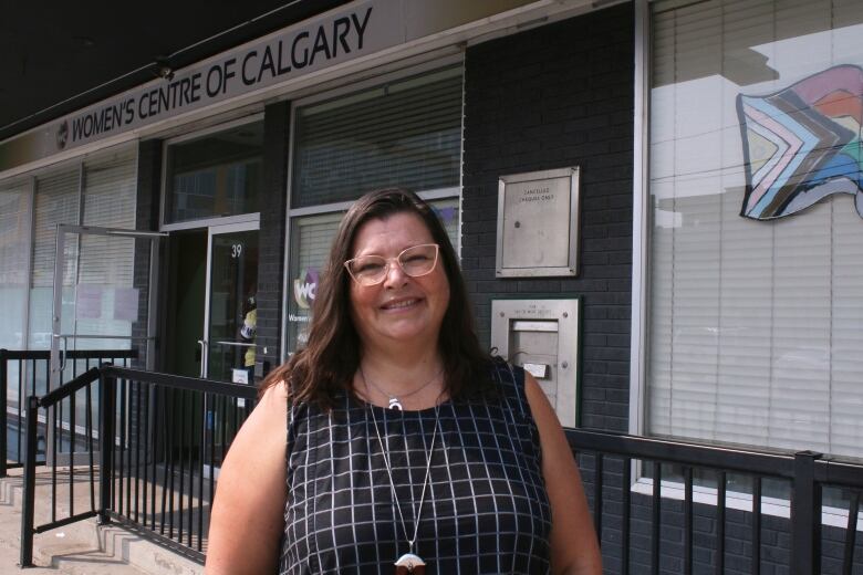 The federal housing advocate smiles in front of the Women's Centre of Calgary's front doors.