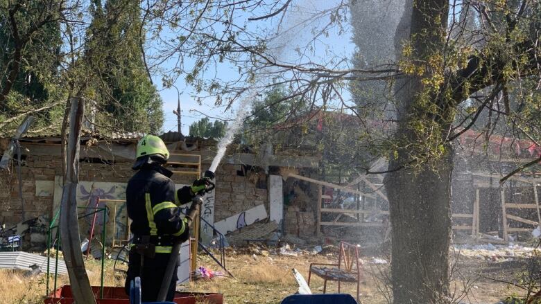 A firefighters sprays water outside of a church in Zaporizhizhia, Ukraine, that was destroyed in a Russian missile strike.