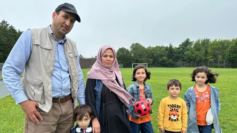 A man and woman are shown at a soccer field in Halifax with four of their children.