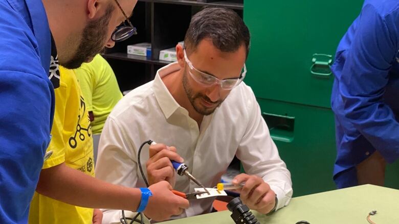 Education minister Stephen Lecce takes part in an interactive soldering lesson as part of his Science North tour in Sudbury, Ont. on Thursday.