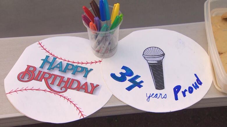 Two baseball-shaped posters reading 