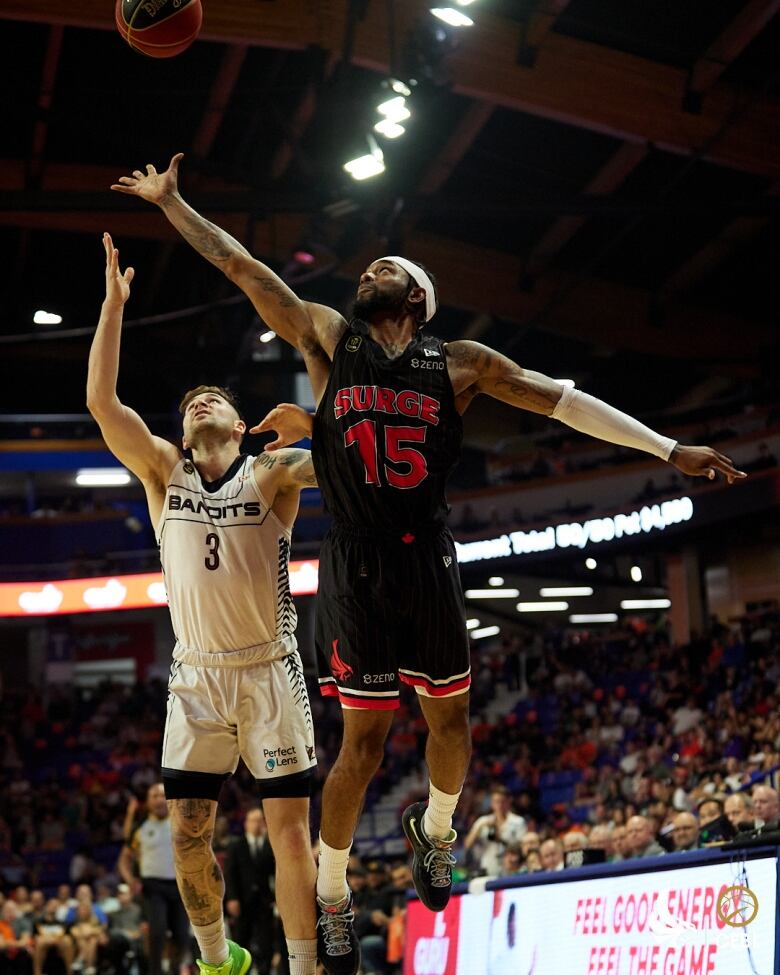 Two men jump for a basketball. 