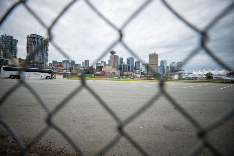 Parking lot seen from a fence with the Vancouver tower and city scape in the background