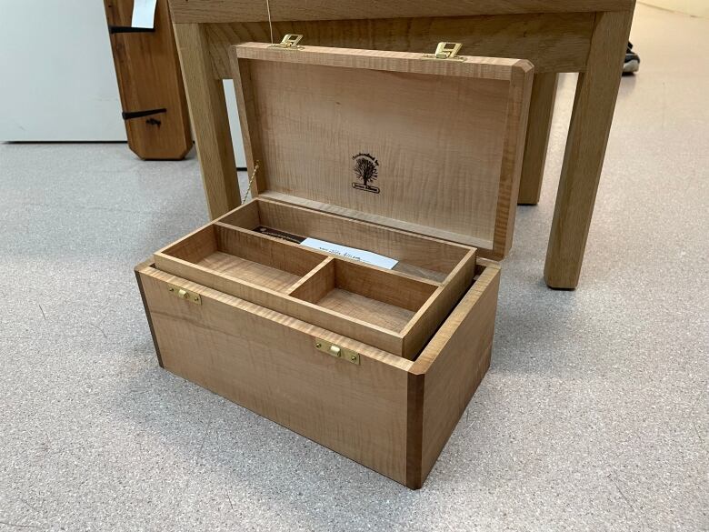 A wooden jewelry box with the top propped open