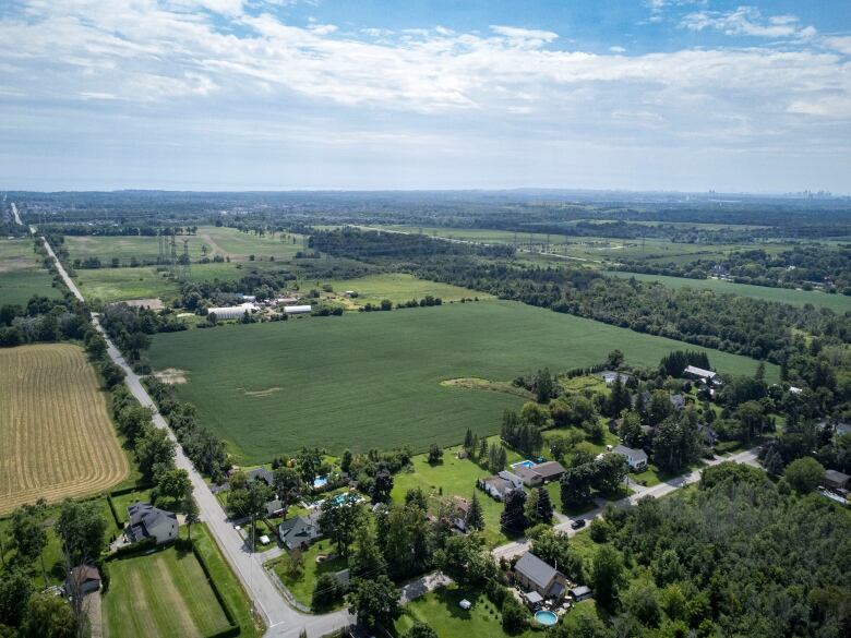 An aerial view of a small hamlet and surrounding green fields.