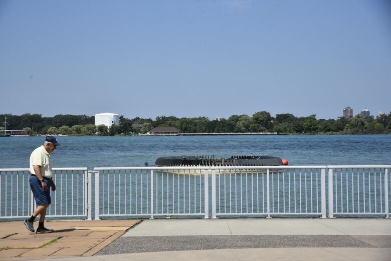 A man walks along the Detroit riverfront