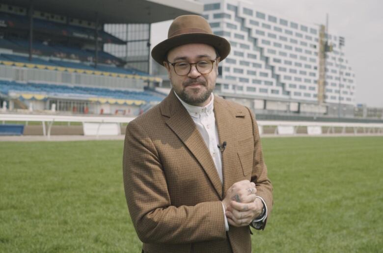 A man in a suit in the middle of a race track.