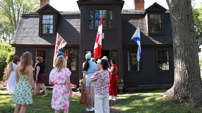 A crowd of onlookers stand in front of the DeGannes-Cosby House in Annapolis Royal.