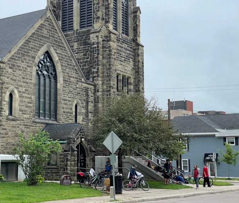 outside of church with people on bicycles standing around