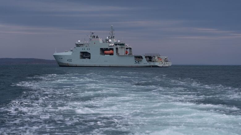 A navy ship sits on the water outside of Iqaluit. 