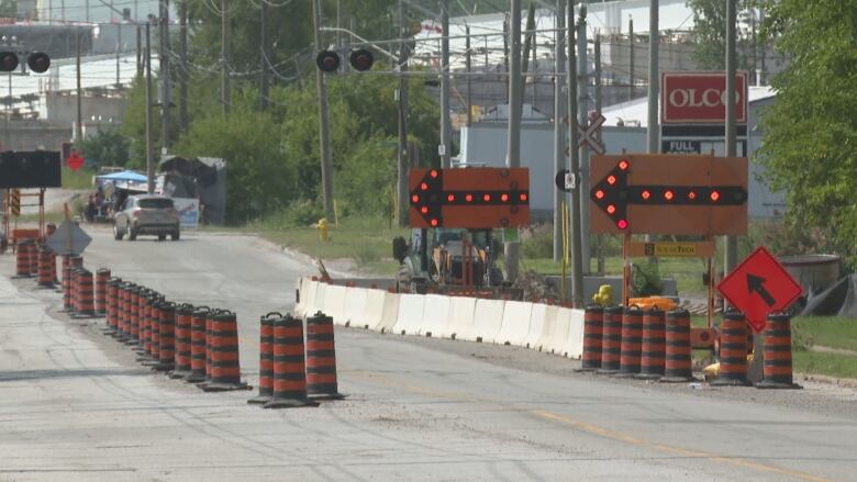 Construction and detour signs on a city street.